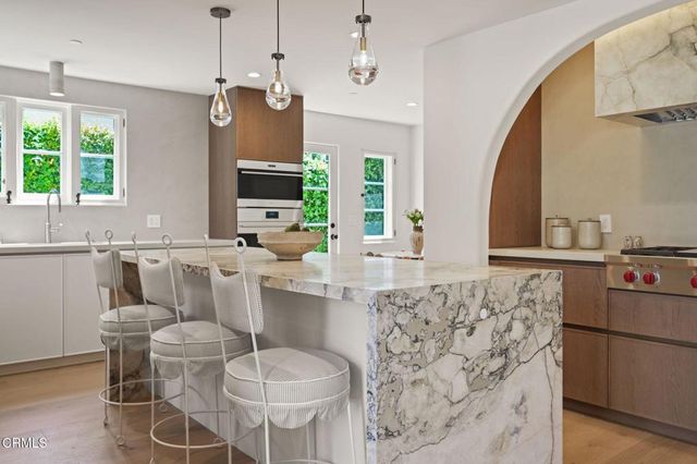 a view of a kitchen with dining area a chandelier and wooden floor