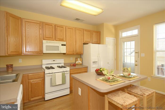 52 Golden Ash Way Gaithersburg, MD 20878 - Photo 5 of 31 a kitchen with a sink stove and white cabinets