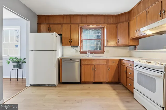a kitchen with a sink a stove a refrigerator and a window