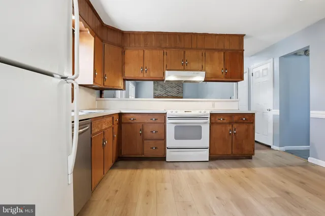 a kitchen with a white stove top oven sink and cabinets