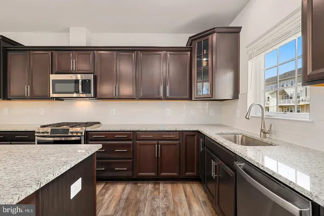 a kitchen with stainless steel appliances granite countertop a sink stove and microwave