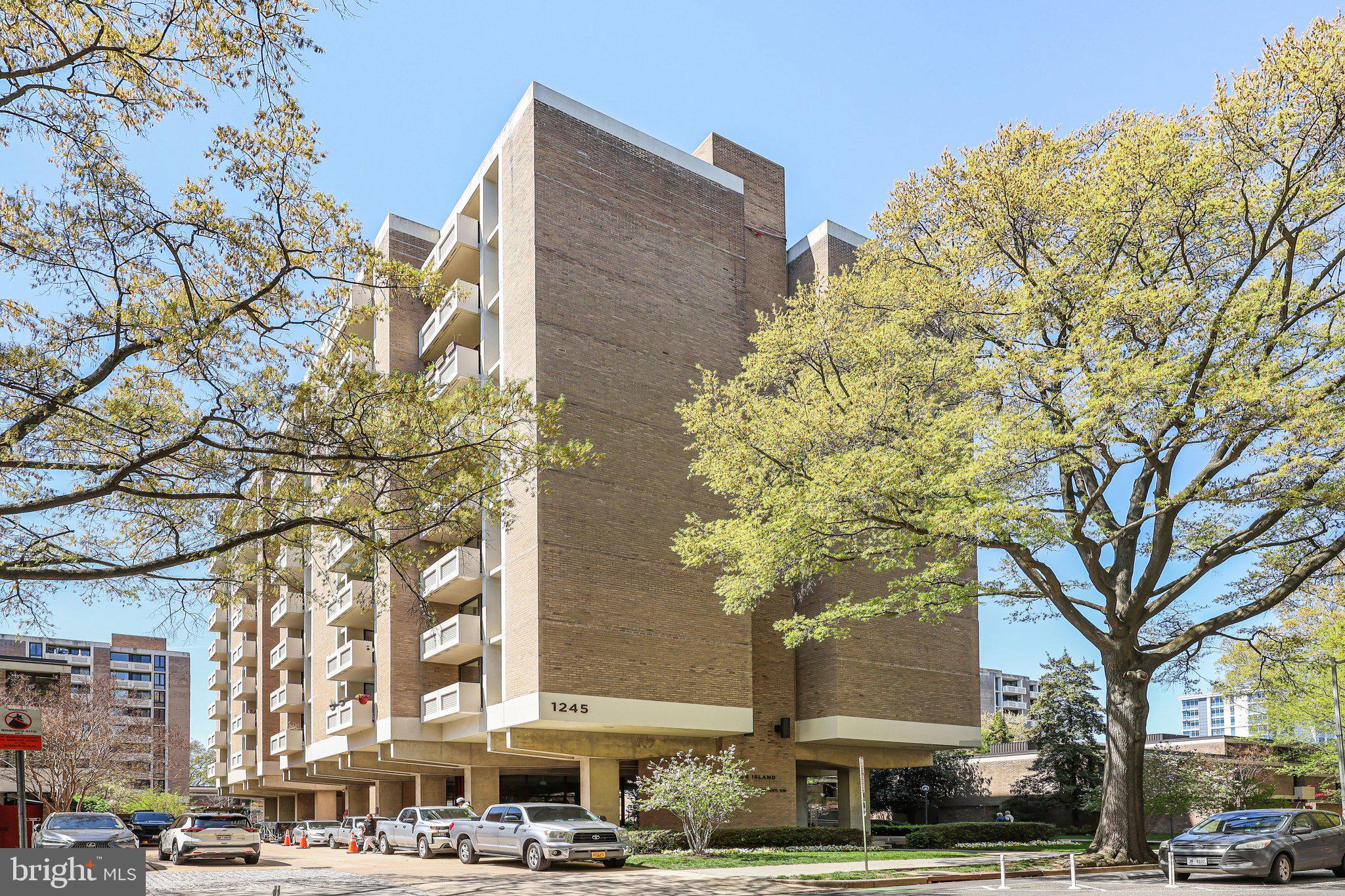 a front view of a building with large trees