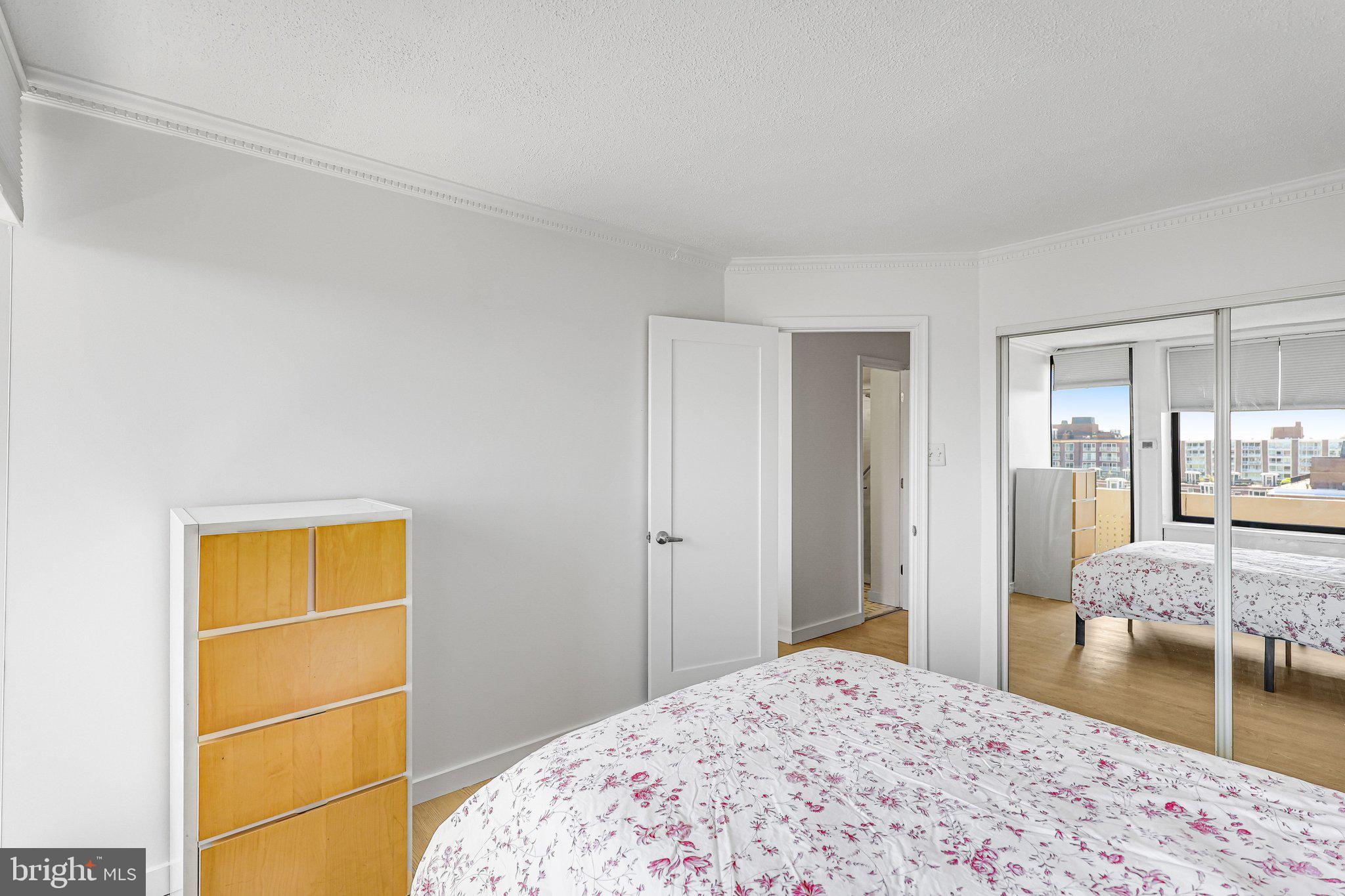 1245 4th Street Southwest, Unit E711 Washington, DC 20024 - Photo 14 of 33 a bedroom with a bed and a dresser