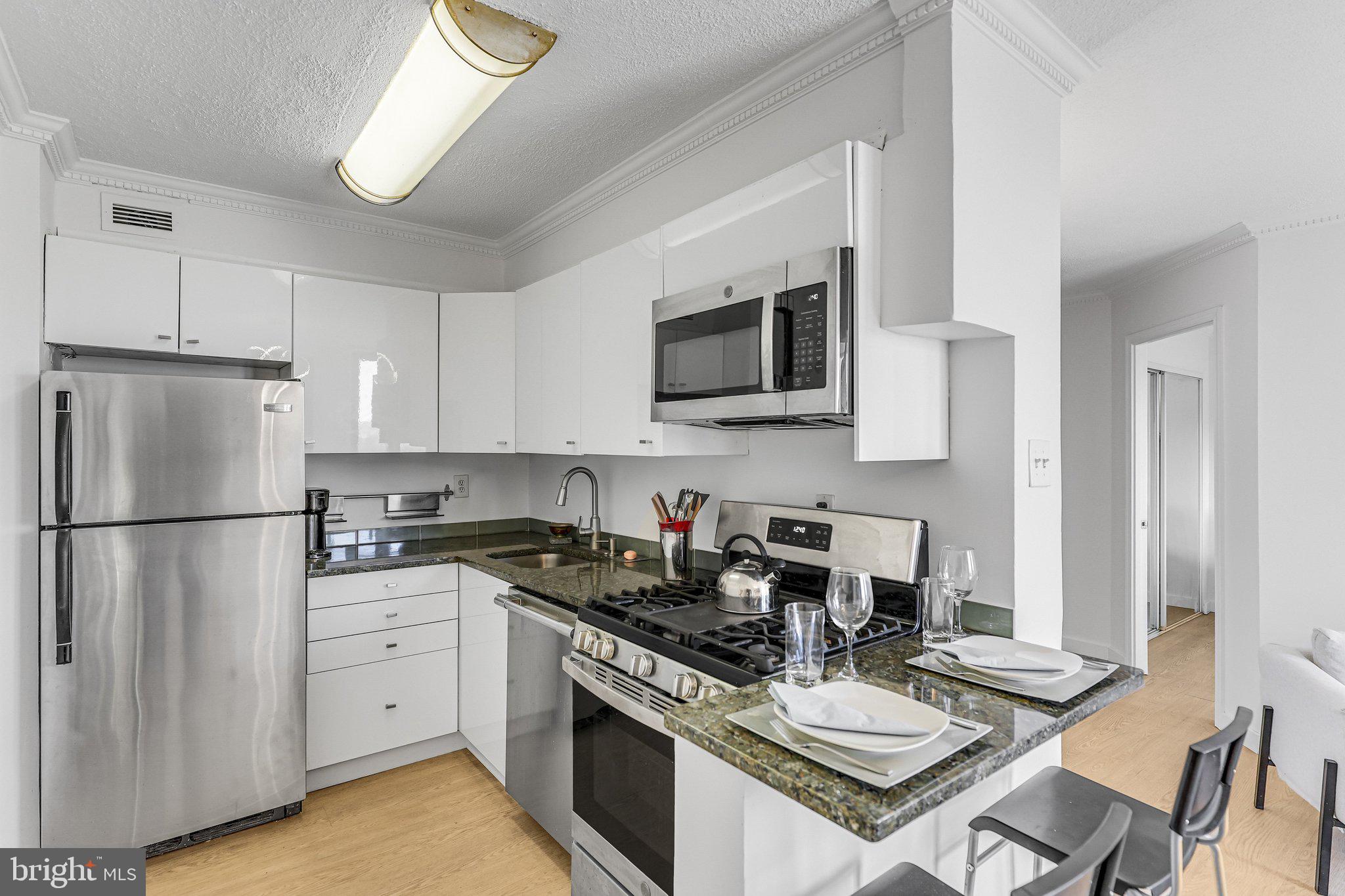 1245 4th Street Southwest, Unit E711 Washington, DC 20024 - Photo 7 of 33 a kitchen with a white stove top oven and refrigerator