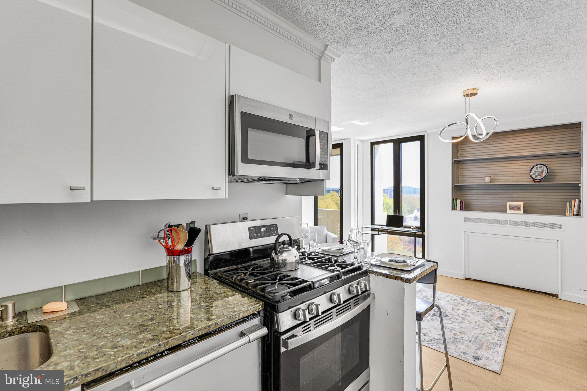 1245 4th Street Southwest, Unit E711 Washington, DC 20024 - Photo 8 of 33 a kitchen with stainless steel appliances granite countertop a sink stove and cabinets