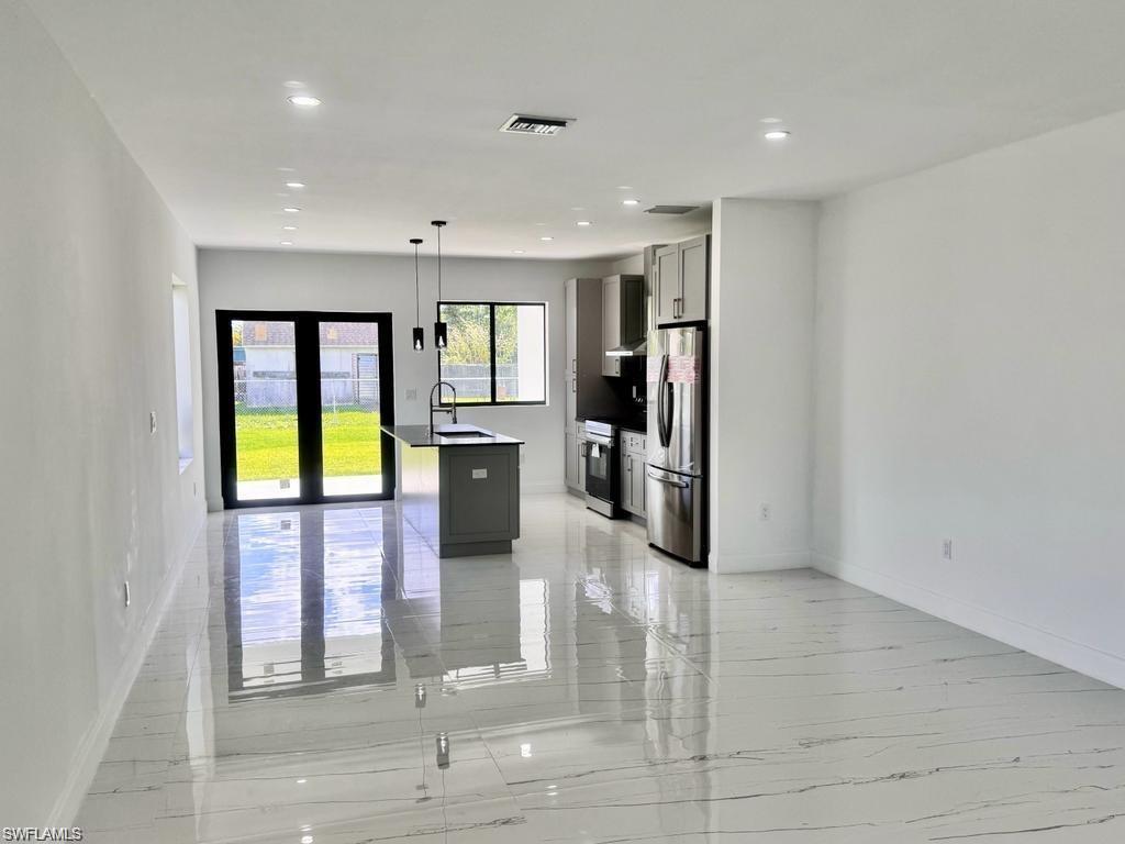 871 Southwest 2nd Street Homestead, FL 33034 - Photo 4 of 12 a kitchen with stainless steel appliances granite countertop a refrigerator and a sink