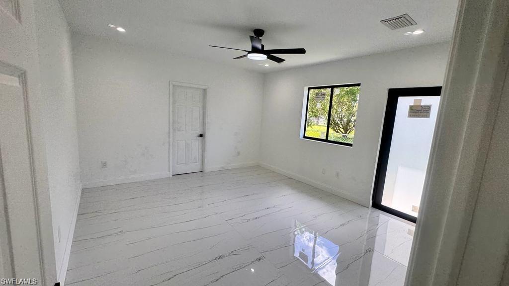 871 Southwest 2nd Street Homestead, FL 33034 - Photo 6 of 12 en empty room with windows and ceiling fan