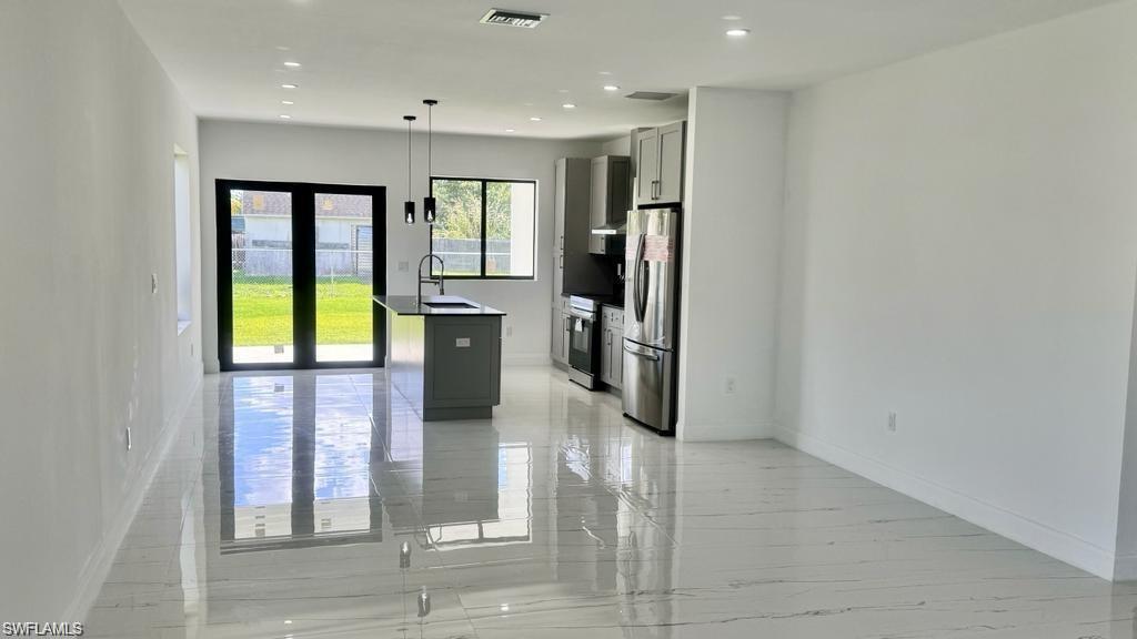 871 Southwest 2nd Street Homestead, FL 33034 - Photo 8 of 12 a view of a hallway with wooden floor and a refrigerator