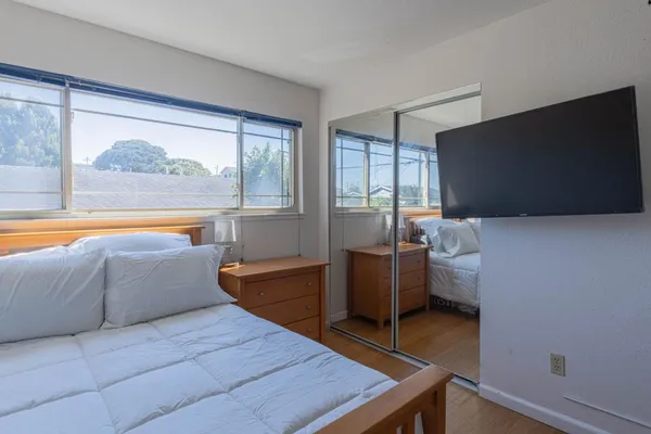 a bedroom with a bed and wooden floor