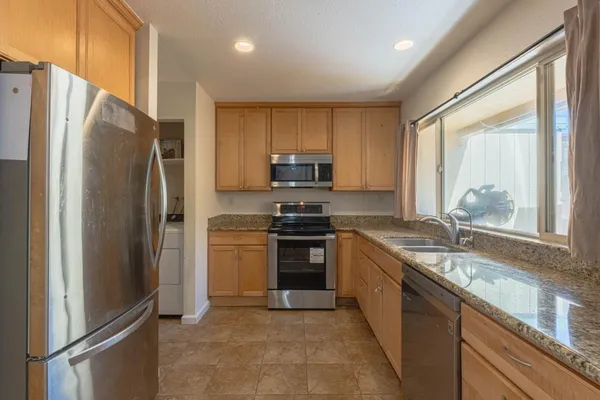 a kitchen with stainless steel appliances granite countertop a refrigerator stove and microwave