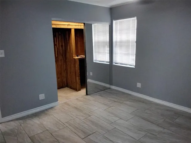 an empty room with windows and closet