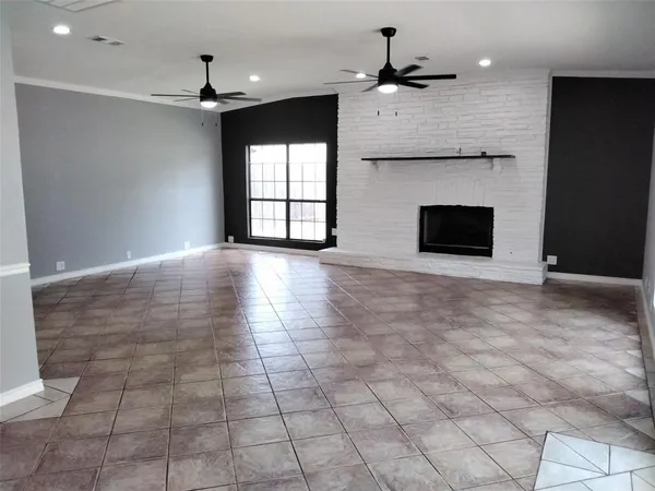 a view of an empty room with a fireplace and a window