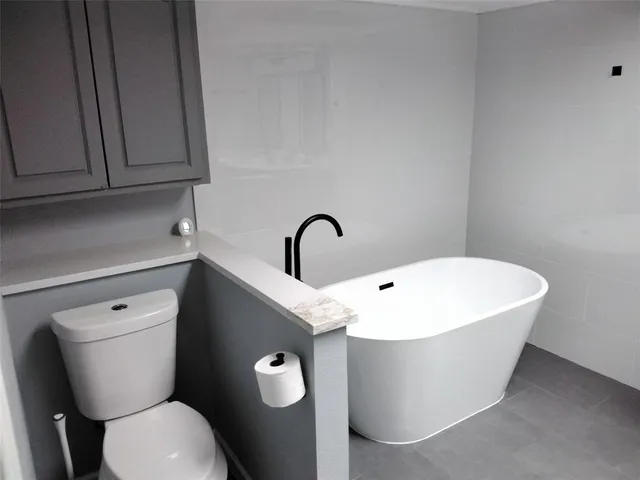 a close view of a sink a toilet and a mirror