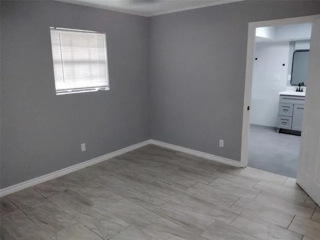 an empty room with a bathroom and a sink