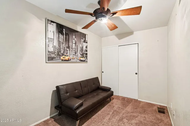 a room with chandelier fan and windows