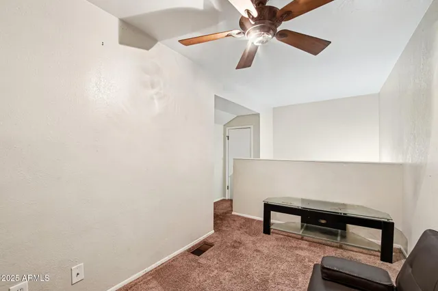 a view of a workspace with furniture and a fan