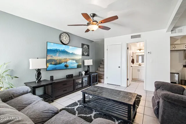 a living room with furniture a chandelier and a rug