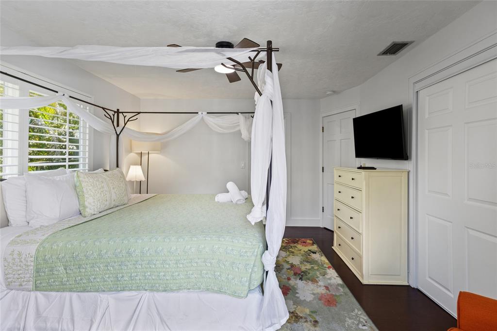 315 Spring Avenue Anna Maria, FL 34216 - Photo 33 of 63 a bedroom with a bed and a flat tv screen on dresser