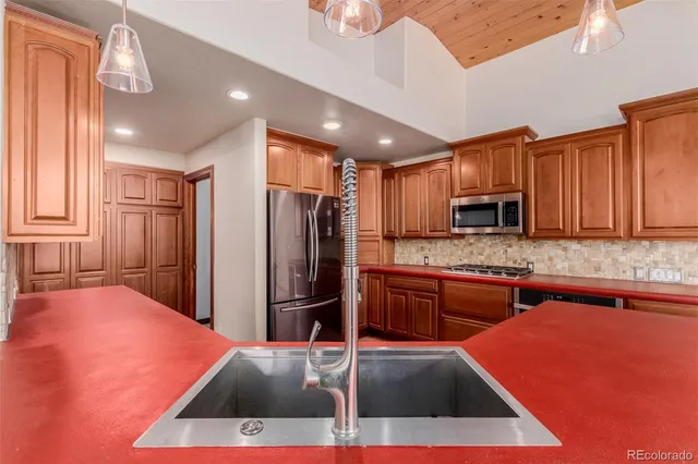a kitchen with stainless steel appliances kitchen island granite countertop a refrigerator and a stove top oven