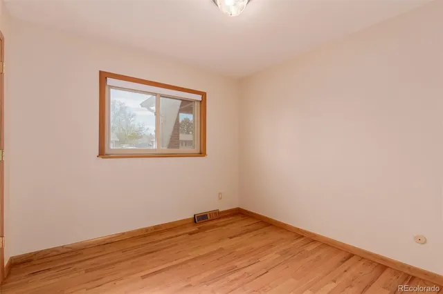 a view of empty room with wooden floor