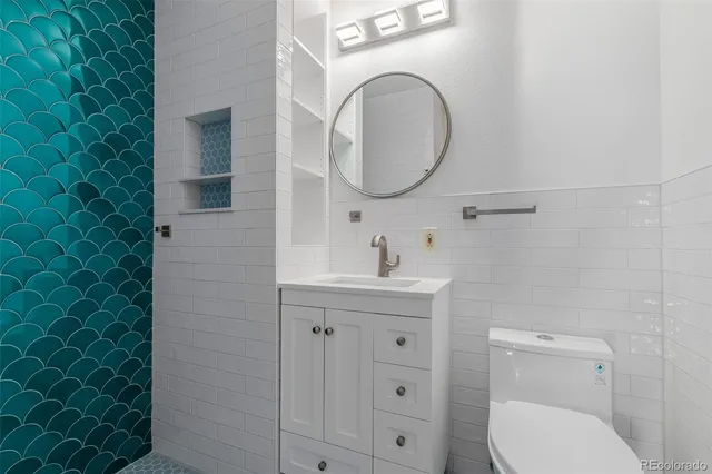 a bathroom with a toilet sink vanity and mirror