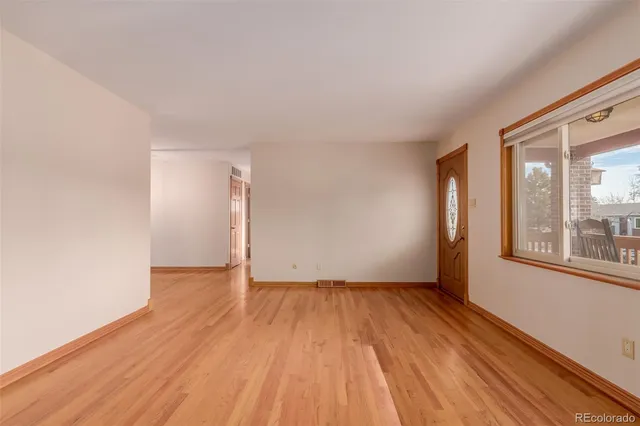 wooden floor in an empty room with a window