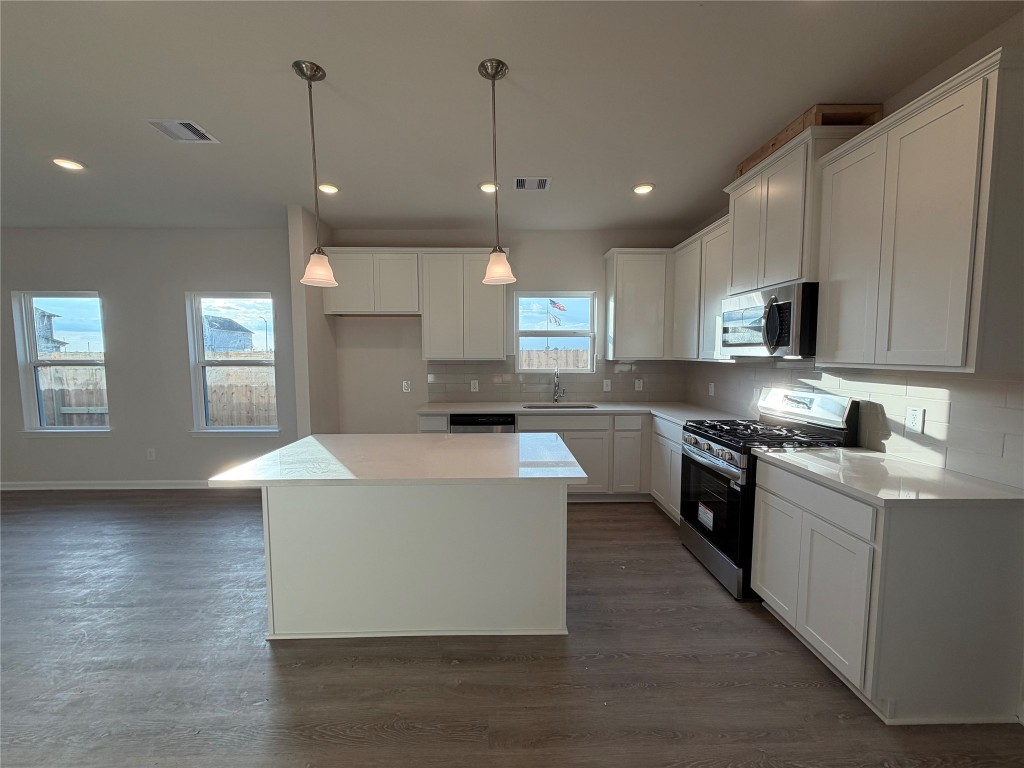 429 Stone Placa Trail Pattison, TX 77423 - Photo 4 of 17 a large kitchen with stainless steel appliances granite countertop a stove a sink dishwasher a refrigerator white cabinets and wooden floor