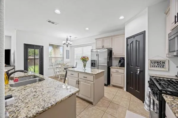 a kitchen with a refrigerator sink and cabinets