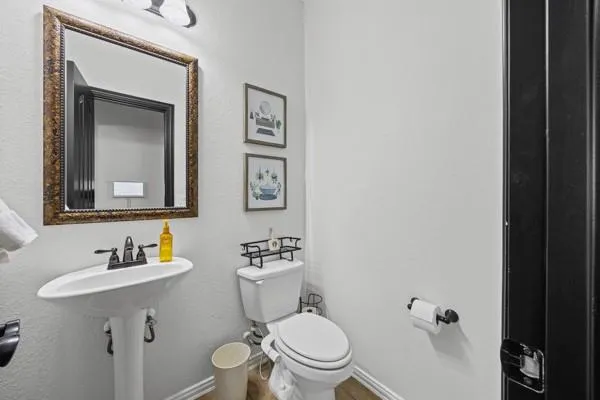 a bathroom with a toilet a sink and mirror