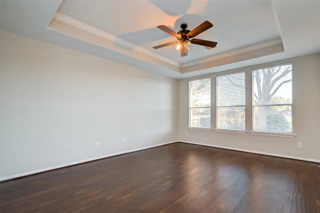 a view of a big room with wooden floor and windows