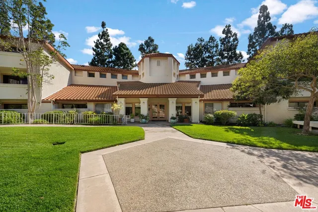 a view of a big house with a big yard and large trees