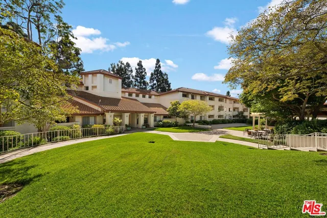 a view of a house with a big yard and large trees