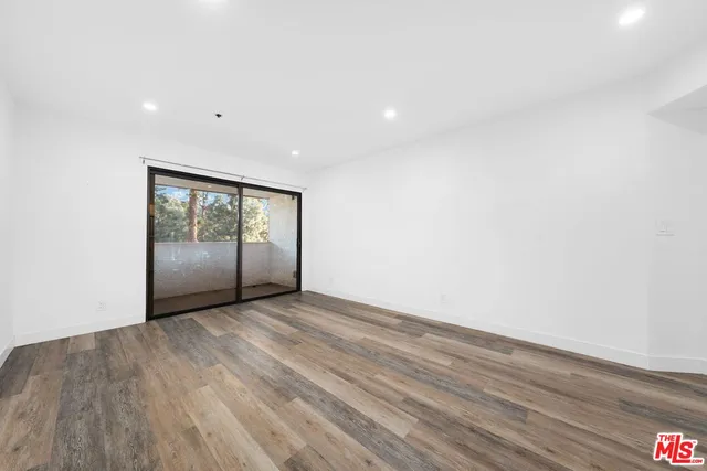 an empty room with wooden floor and sliding door