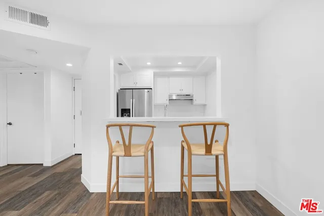 a dining room with wooden floor and white walls