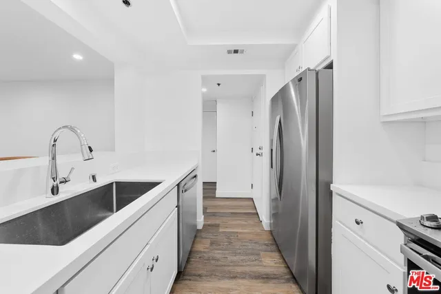 a kitchen with granite countertop a refrigerator and a sink