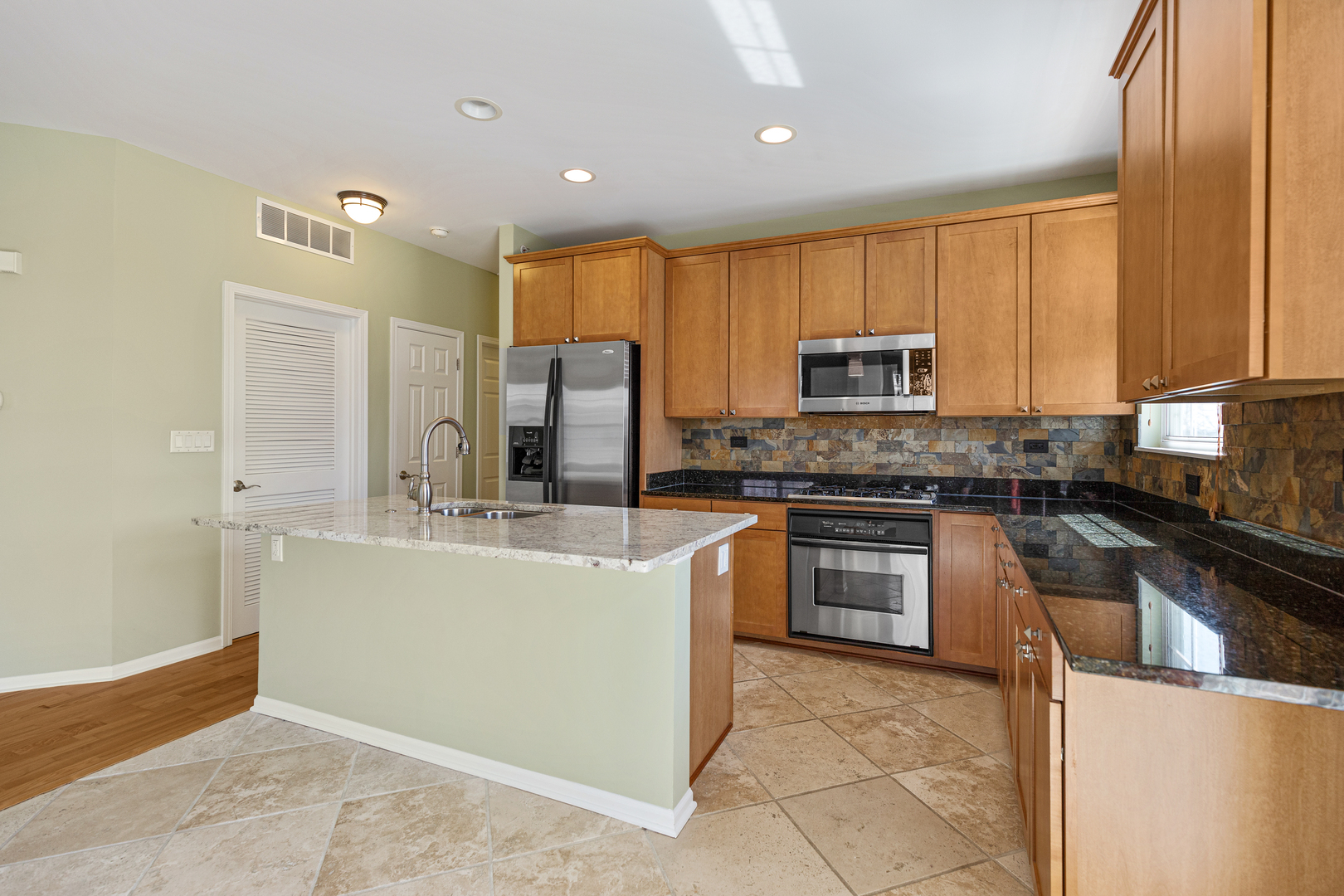 1388 Scarboro Road, Unit 1103 Schaumburg, IL 60193 - Photo 4 of 17 a kitchen with stainless steel appliances granite countertop a stove a sink and a refrigerator