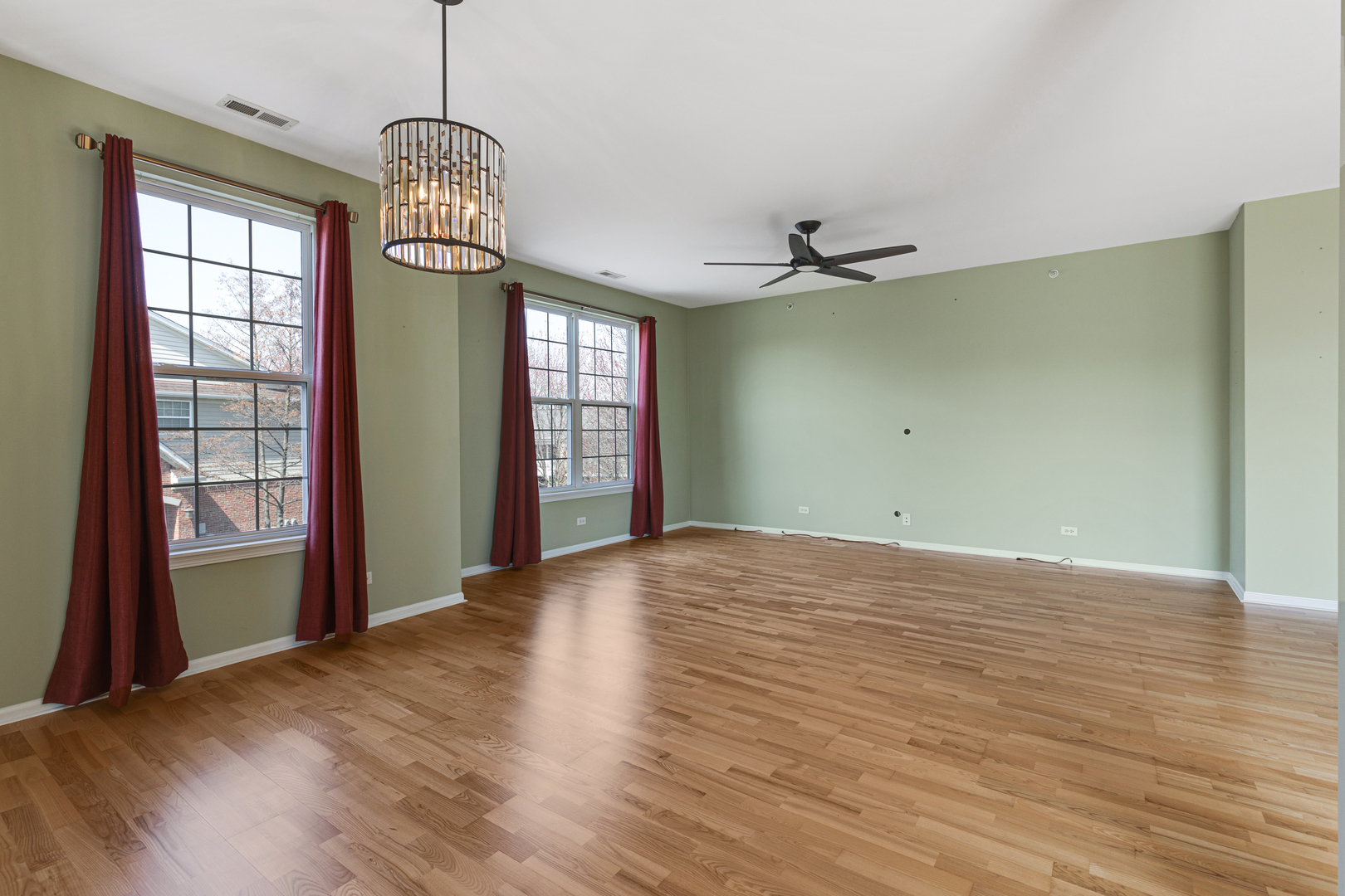 1388 Scarboro Road, Unit 1103 Schaumburg, IL 60193 - Photo 7 of 17 an empty room with chandelier fan and windows