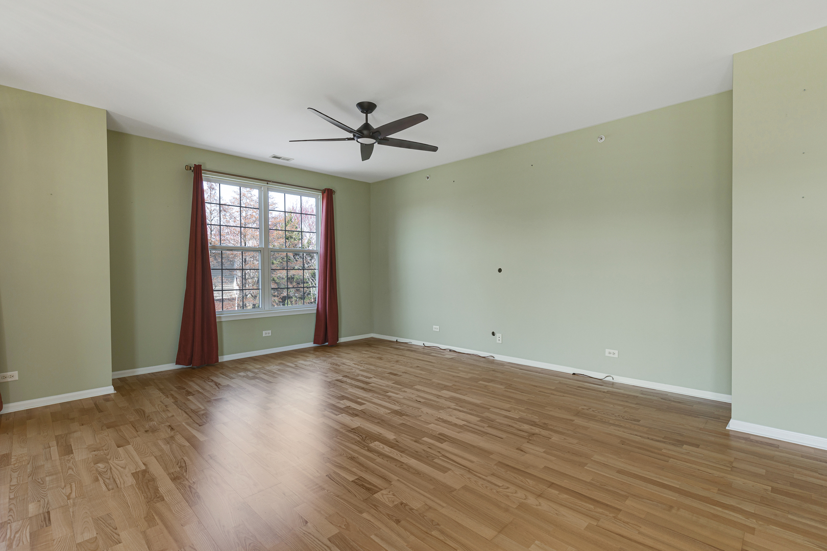 1388 Scarboro Road, Unit 1103 Schaumburg, IL 60193 - Photo 8 of 17 an empty room with wooden floor fan and windows