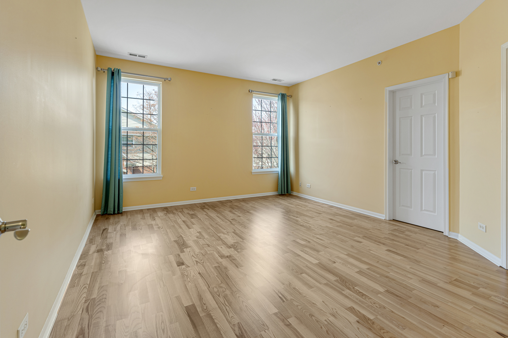 1388 Scarboro Road, Unit 1103 Schaumburg, IL 60193 - Photo 10 of 17 a view of an empty room with wooden floor and a window
