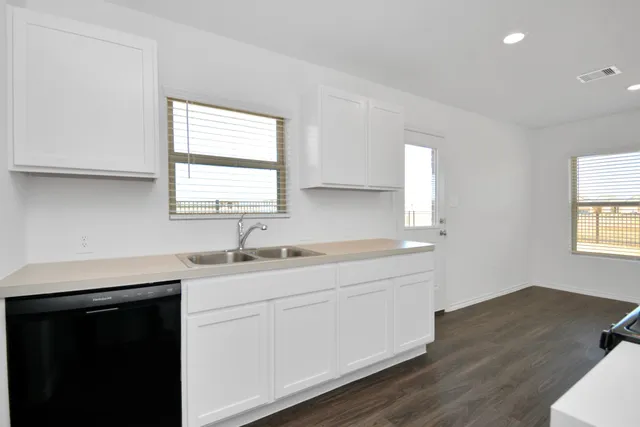 a kitchen with a sink stove and cabinets