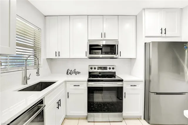 a kitchen with stainless steel appliances a stove a sink and a refrigerator