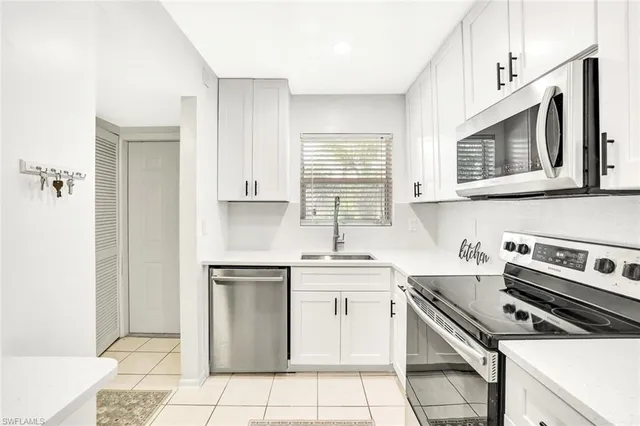a kitchen with stainless steel appliances a stove sink and microwave