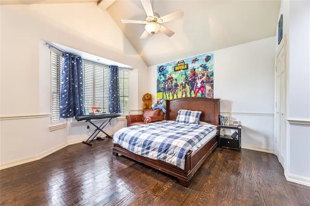 a bedroom with a bed a dresser and wooden floor