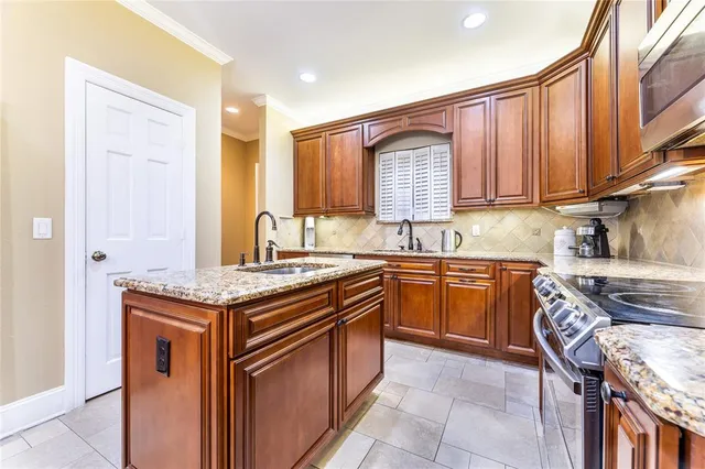 a kitchen with granite countertop a sink stove and cabinets