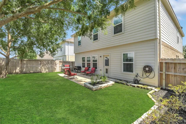 a view of a backyard with table and chairs and a large tree