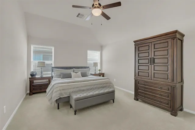 a spacious bedroom with a bed and a chandelier