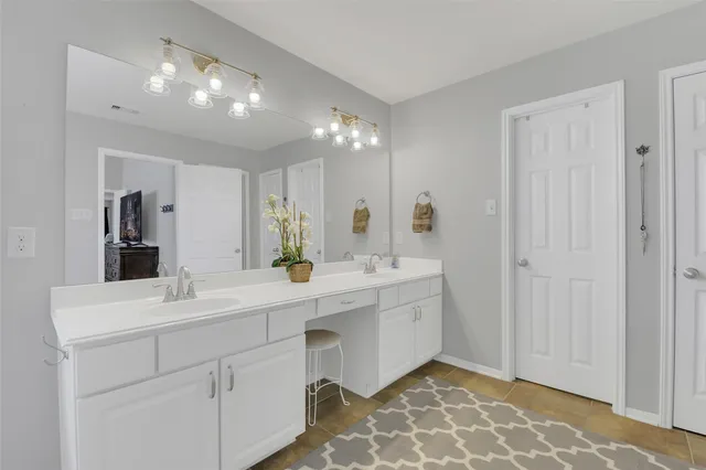 a spacious bathroom with double vanity and a mirror
