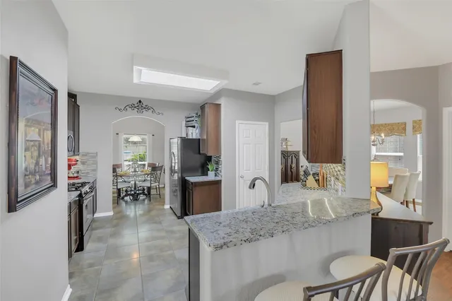 a kitchen with stainless steel appliances granite countertop a sink and a refrigerator