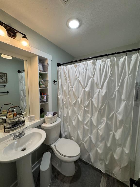 1525 Smith Road Howe, TX 75459 - Photo 15 of 24 a bathroom with a sink a toilet and shower curtain
