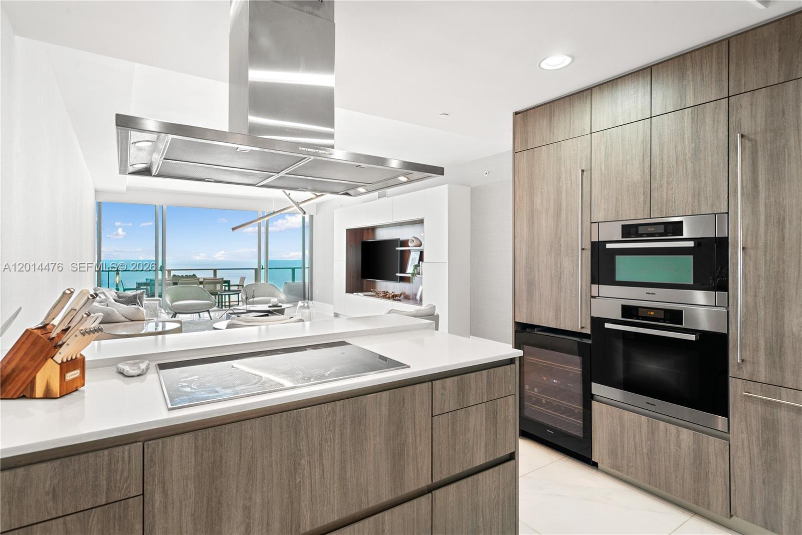 360 Ocean Drive, Unit 1106S Key Biscayne, FL 33149 - Photo 10 of 67 Kitchen with Living Room View – Designed for both style and function, the kitchen includes built-in ovens, full-height cabinetry, a wine cooler, and a generous prep surface. The open sightline to the living room and water view adds to the home’s airy feel.
